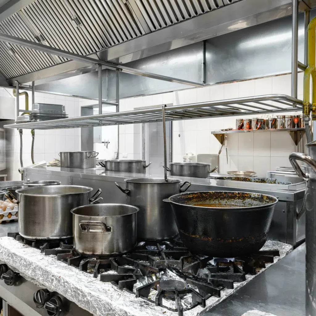 Cuánto cuesta un seguro de bar en Madrid: cocina profesional con fogones de gas, ollas al fuego y campana extractora