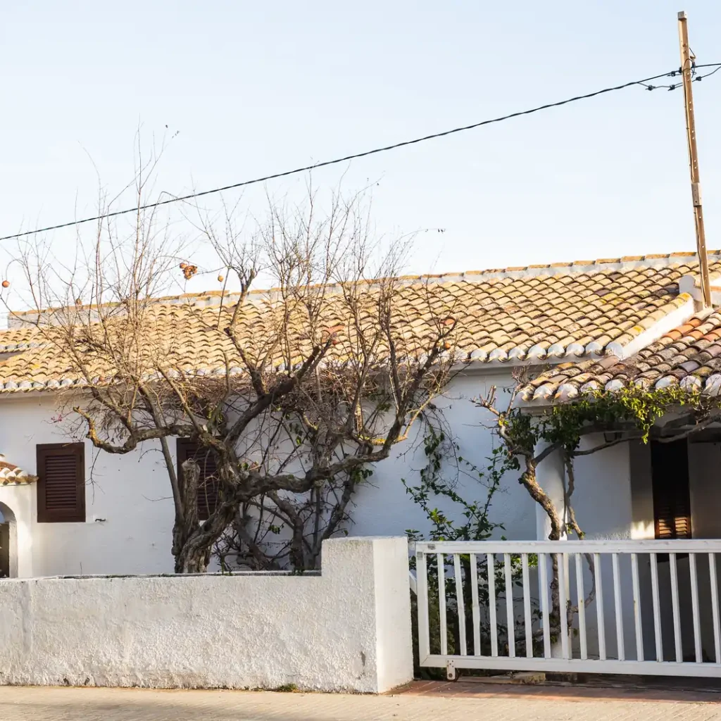 Cuánto cuesta un seguro de casa en Zaragoza: casa blanca de una planta con tejado de teja árabe, muro y verja