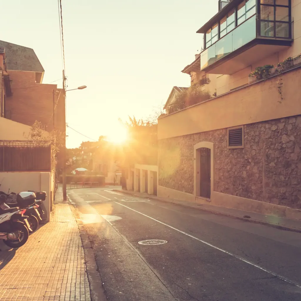 Precio del seguro de una moto de 125 en Madrid: scooters aparcados en la acera de una calle residencial al atardecer