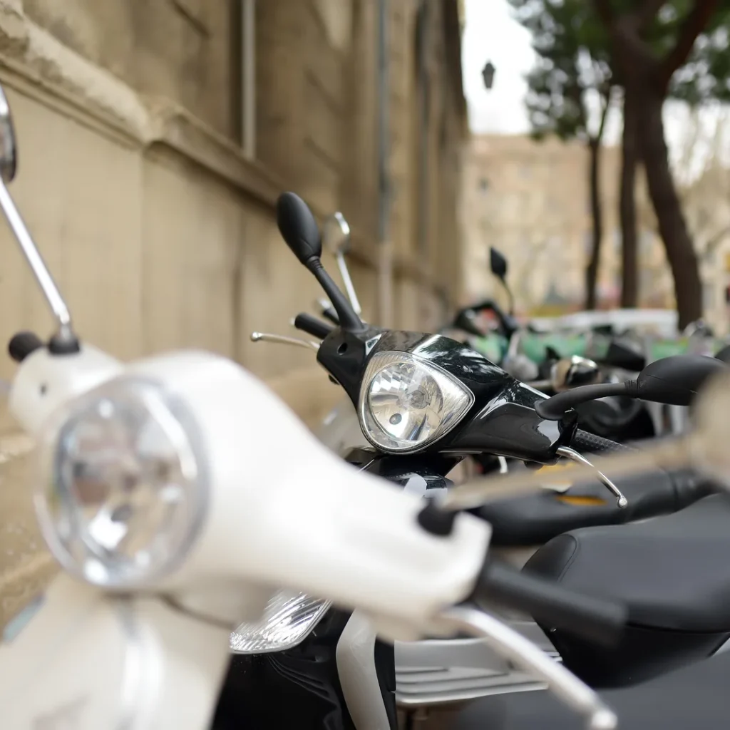 Precio del seguro de una moto de 125 en Zaragoza: scooters aparcados en fila junto a un muro de piedra
