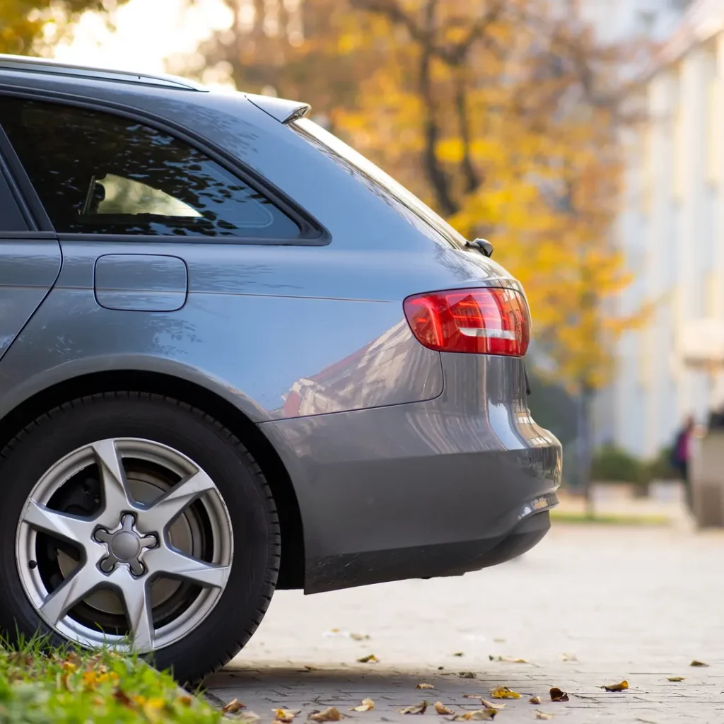 Precio del seguro de coche para novel en Zaragoza: parte trasera de un coche familiar gris aparcado junto a la acera